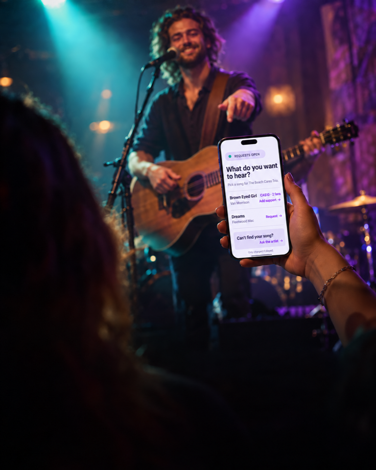 A fan choosing a song request from their phone while a musician performs on stage